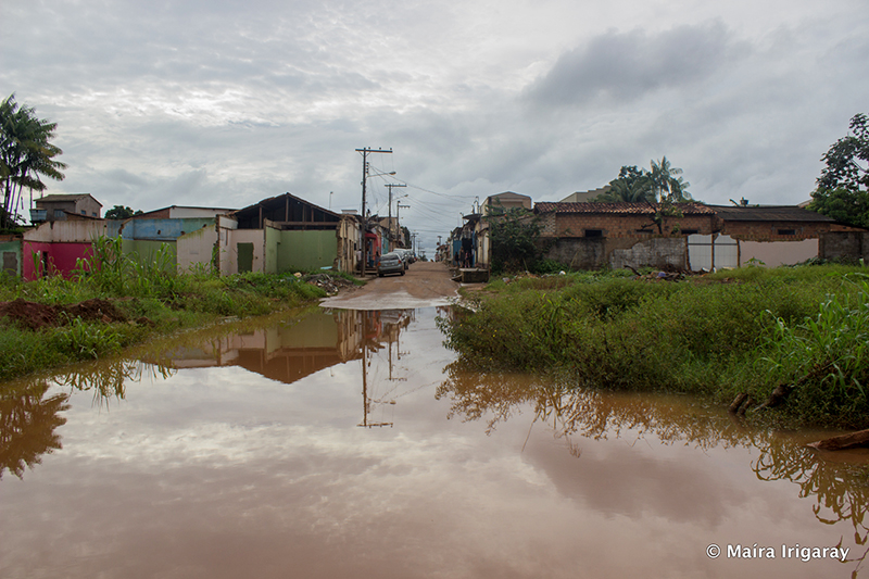 A heavily flooded dirt street approaches houses in Altamira.
