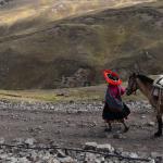 Mujer y caballo en zona montañosa de Perú