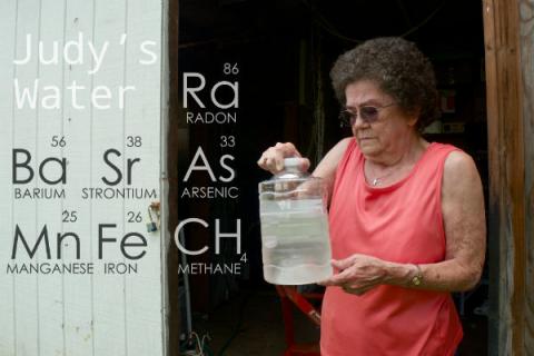 Photo: Judy Eckert, a resident of Pennsylvania who lives beside a fracking well, holds water contaminated with arsenic extracted from her private well. Credit: Public Herald/Creative Commons.