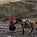 Mujer y caballo en zona montañosa de Perú