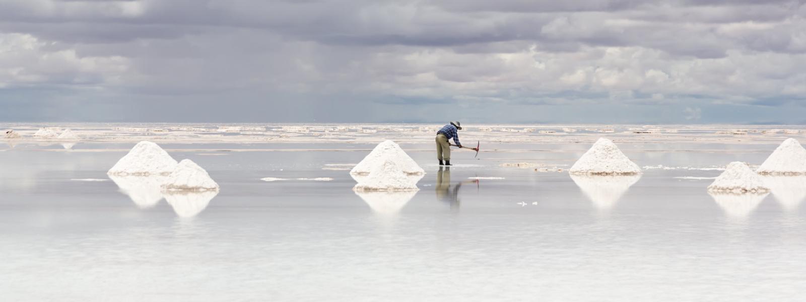 Worker performing harvesting salt on the salt lake Salar de Uyuni, Bolivia