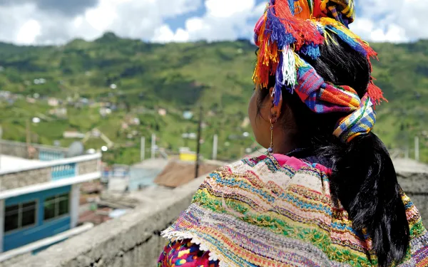 mayan woman overlooking town, in traditional dress