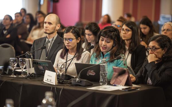 tres abogadas se sientan ante una larga mesa en el tribunal