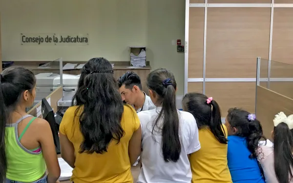 niñas frente un escritorio entregando un escrito legal