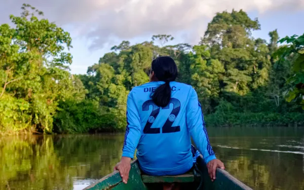 A man sitting in a boat sailing down the Amazon River.