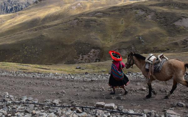 Mujer y caballo en zona montañosa de Perú