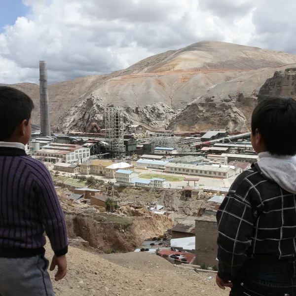 two boys standing before smoke stack 
