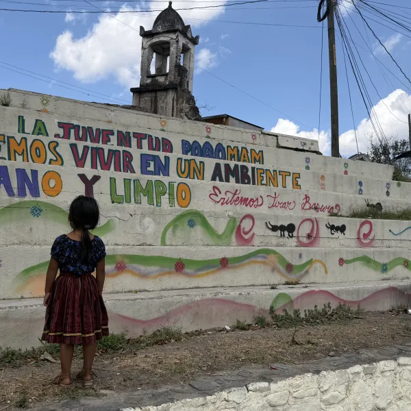 Niña frente a un mural contra la contaminación en Santa Cruz Chinautla, Guatemala