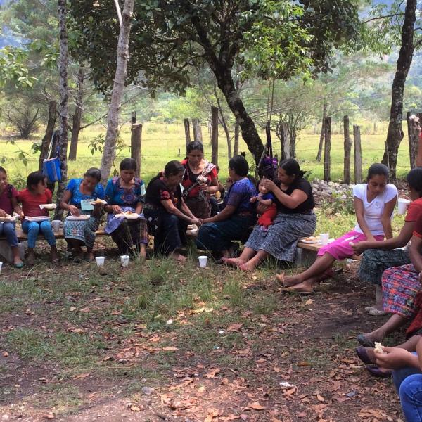 women community leaders of Ixquisis gather together beneath large trees. 